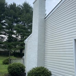 Chimney & Exterior Wall — White house exterior with chimney masonry work.